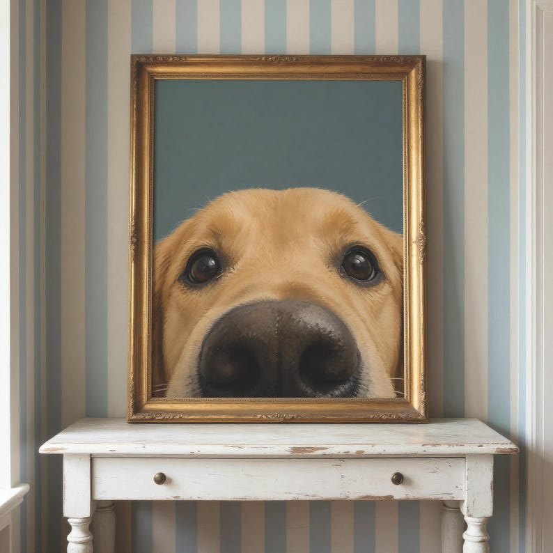 Puede incluir: Una pieza de arte mural enmarcada que presenta un retrato en primer plano de un perro de color dorado con grandes ojos oscuros y una nariz negra prominente. La obra est&aacute; en un marco rectangular dorado ornamentado, mostrando la cara desde los ojos.