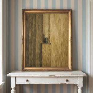 May include: A rectangular oil painting in a decorative gold frame featuring an abstract composition of vertical brushstrokes in shades of olive green, tan, and cream, with a small, centered dark green rectangular element on a horizontal ledge.
