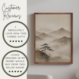 May include: A framed wall art print featuring a monochromatic landscape of misty mountains and a lone pine tree in the foreground. The artwork is displayed in a thin brown wooden frame. The text Customer Reviews appears above two circular badges.