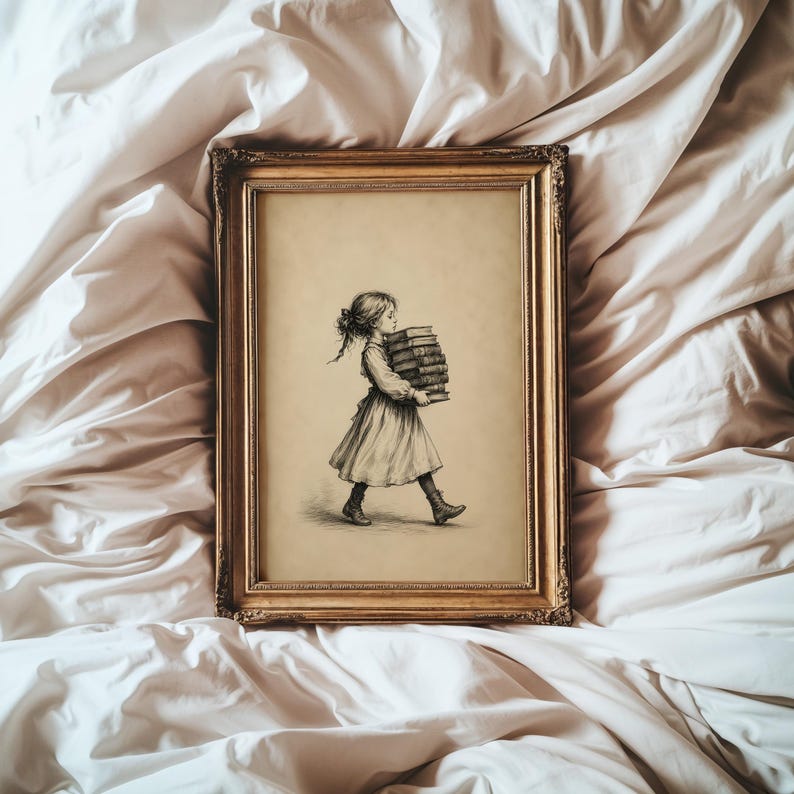 May include: A rectangular gold-toned ornate frame containing a black and white sketch of a child with hair tied back, wearing a dress and boots, walking while carrying a tall stack of books. The artwork is set against a light beige background.