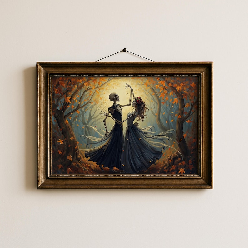 May include: A framed wall art print depicting two skeletons dancing in a forest filled with autumn leaves. One skeleton wears a dark suit and the other wears a long dark dress with a red floral headpiece. The scene is illuminated by a bright light.