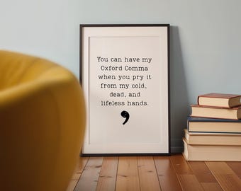 May include: A rectangular framed wall art piece featuring black typewriter-style text on a white background that reads: You can have my Oxford Comma when you pry it from my cold, dead, and lifeless hands, followed by a black comma symbol.