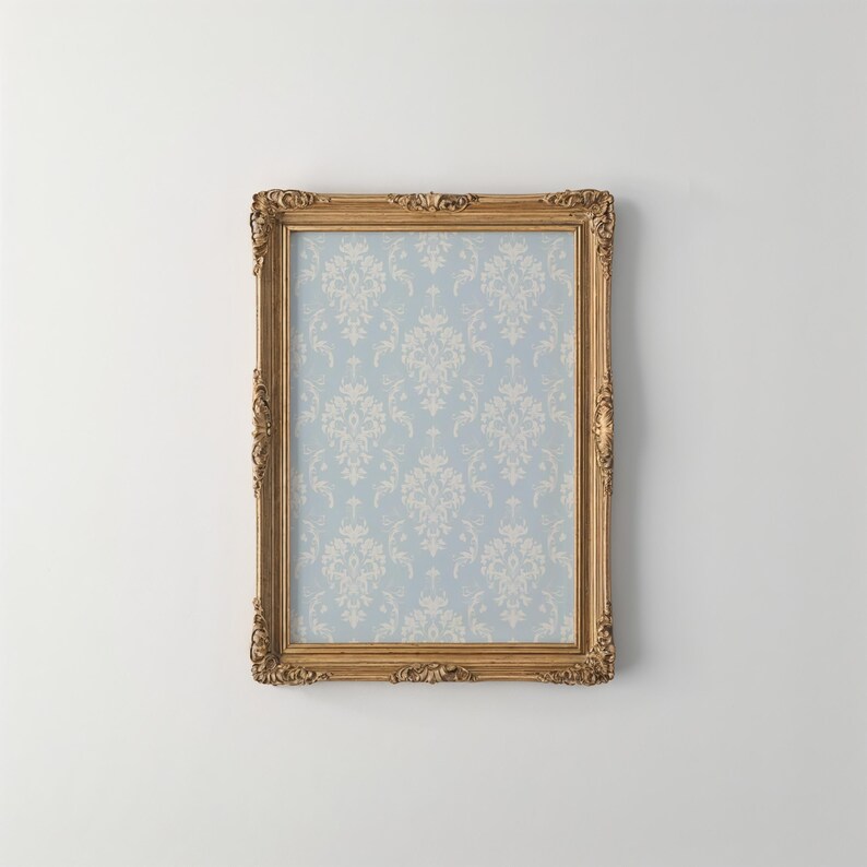 May include: A rectangular picture frame with an ornate, carved gold finish. The frame encloses a light blue background featuring a repeating white damask pattern. The design includes intricate scrollwork and floral motifs along the edges.