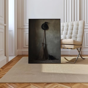 May include: A framed rectangular wall art print featuring a dark, moody scene with a black witch hat hanging above a rustic wooden broomstick, with a small black cat sitting on the floor in the corner against a textured grey wall background.