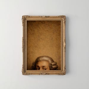 Op de afbeelding: Een ingelijste print met een historische figuur met een gepoederde pruik, die achter een sierlijke gouden lijst vandaan komt. De sepia-achtergrond creëert een vintage esthetiek. Alleen de ogen van het onderwerp zijn zichtbaar, wat intrige toevoegt.