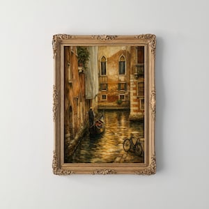 May include: A framed painting depicts a Venetian canal scene. The artwork features a gondola, buildings with arched windows, and a bicycle. The color palette includes warm tones of gold, brown, and orange, with a touch of blue in the water.