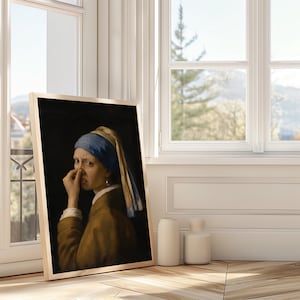 May include: A framed print featuring a painting of a person wearing a blue headscarf and a brown jacket, holding their nose with one hand. The person has a disgusted facial expression. The artwork is set against a dark background.