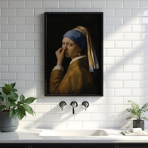 May include: A framed wall art print featuring a parody of the Girl with a Pearl Earring, showing a figure wearing a blue headscarf and brown garment, holding their nose with one hand against a dark background, displayed in a black frame.