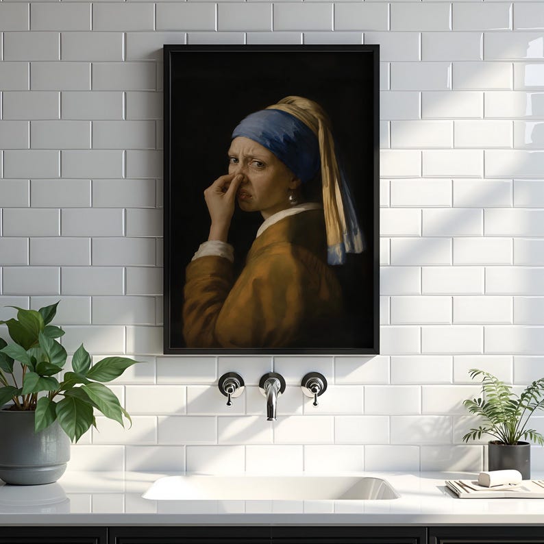 May include: A framed wall art print featuring a parody of the Girl with a Pearl Earring, showing a figure wearing a blue headscarf and brown garment, holding their nose with one hand against a dark background, displayed in a black frame.