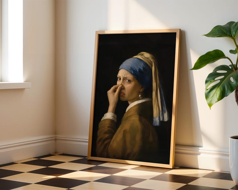May include: A framed art print featuring a parody of the Girl with a Pearl Earring, depicting a person wearing a blue headscarf and brown jacket, holding their nose with a disgusted expression against a dark background.