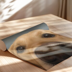 Puede incluir: Una hoja de papel enrollada que presenta una ilustraci&oacute;n digital en primer plano y gran angular del rostro de un perro de color dorado. El perro tiene ojos grandes de color marr&oacute;n oscuro y una nariz prominente y oscura algo distorsionada.