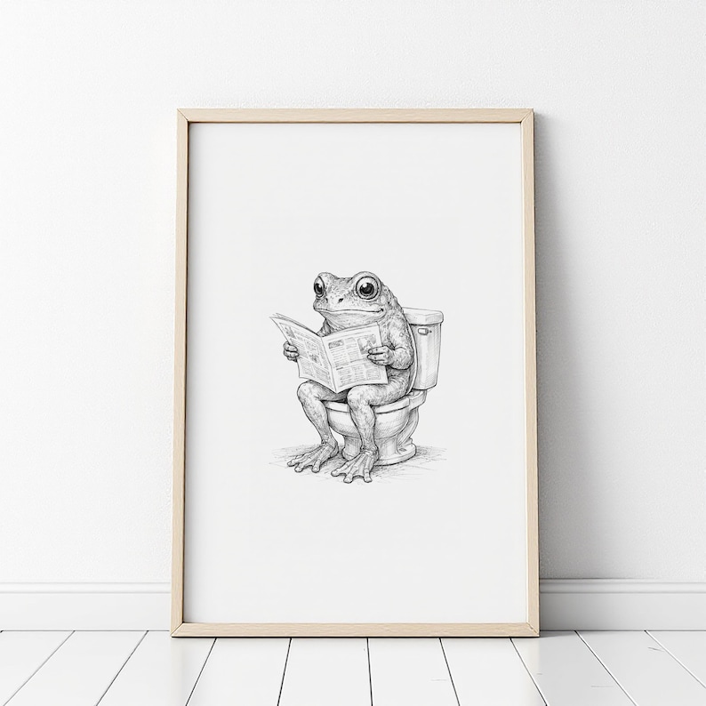 Puede incluir: Impresi&oacute;n en blanco y negro enmarcada de una rana sentada en un inodoro, leyendo un peri&oacute;dico. La rana y el inodoro est&aacute;n representados con sombreado detallado. La obra de arte est&aacute; enmarcada en un marco de madera clara.