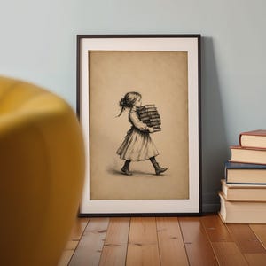 May include: A framed wall art print featuring a sepia-toned illustration of a person with braided hair wearing a dress and boots, walking while carrying a tall stack of books. The artwork is displayed in a simple black frame on a wooden floor.