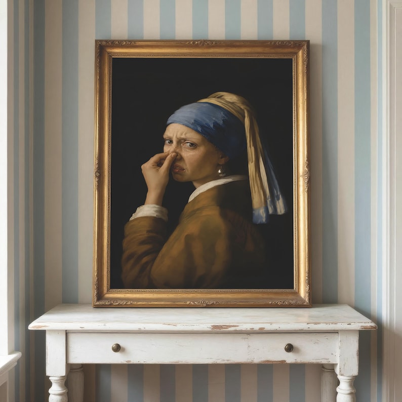 May include: A framed oil painting depicting a person wearing a blue headscarf and a brown jacket, holding their nose with one hand. The figure is set against a dark background and is encased in an ornate gold frame with intricate detailing.