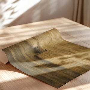 May include: A roll of wallpaper featuring a painterly, abstract design in shades of golden yellow, brown, and tan. The surface displays textured, sweeping brushstroke patterns that create a sense of movement across the material's length.