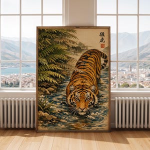 Puede incluir: Impresi&oacute;n art&iacute;stica enmarcada que representa un tigre en un arroyo. El tigre tiene rayas naranjas y negras y est&aacute; parcialmente sumergido en el agua. La obra de arte tiene una est&eacute;tica vintage, con texto japon&eacute;s en la esquina superior derecha. El fondo muestra un paisaje.