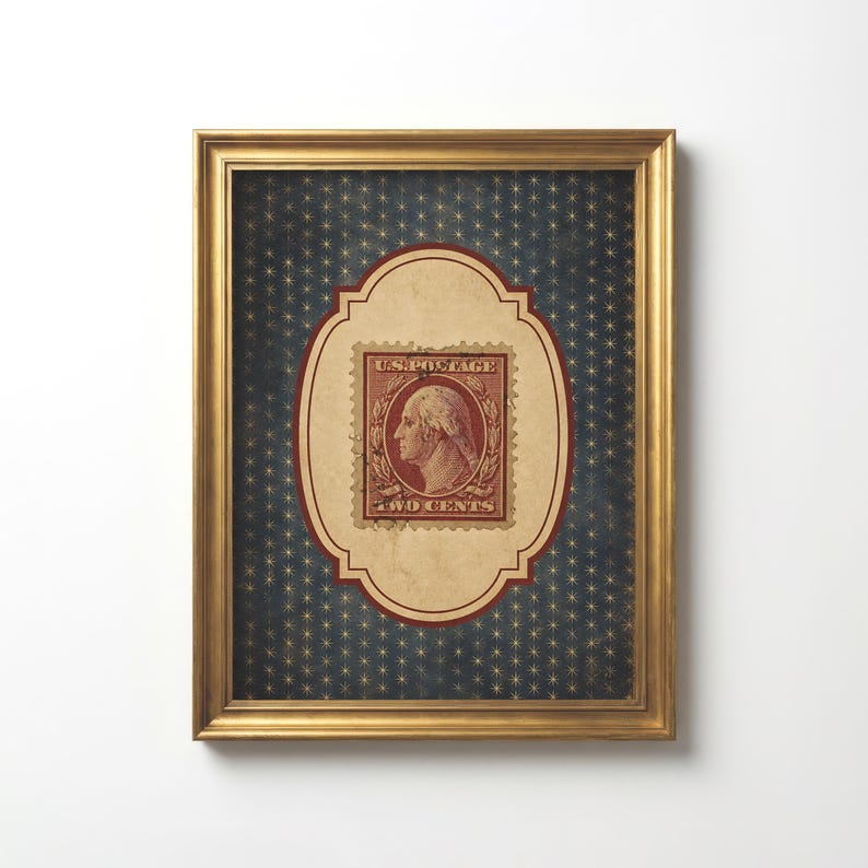 Op de afbeelding: Ingelijste vintage postzegelkunst. Het kunstwerk heeft een gouden lijst, een blauwe achtergrond met een sterrenpatroon en een centraal ontwerp met een rode en beige postzegel. De postzegel leest "U.S. Postage" en "Two Cents", met een profiel van George Washington.