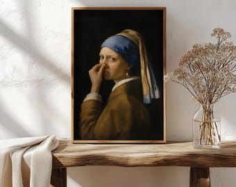 Puede incluir: Una lámina de arte enmarcada que muestra el retrato de una persona con un pañuelo azul y una chaqueta marrón, tapándose la nariz con una mano. La persona lleva un pendiente de perla y aparece sobre un fondo oscuro y sólido.
