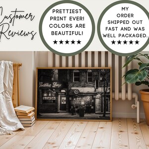 May include: A framed black and white photograph of a vintage building with the text "Cadillac Lounge" in neon. The image is displayed on a wooden floor, with customer reviews in the background.