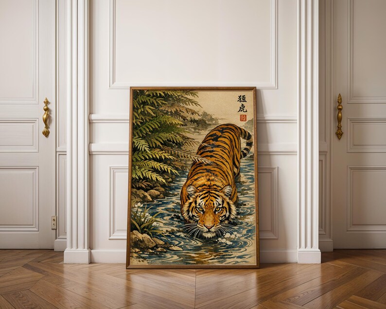 Puede incluir: Una impresi&oacute;n art&iacute;stica enmarcada que presenta un tigre en un arroyo. El tigre tiene rayas naranjas y negras y camina hacia el espectador. La obra de arte tiene una est&eacute;tica vintage con texto japon&eacute;s en la esquina superior izquierda y est&aacute; rodeada por un marco de madera.