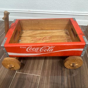 車輪とハンドルが付いたビンテージの木製コカコーラワゴンカート。