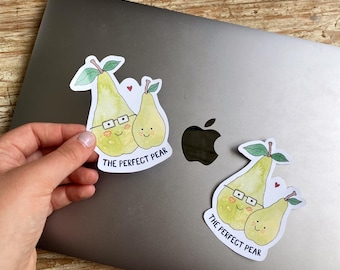 May include: Two stickers featuring cartoon pears with smiling faces and the text "THE PERFECT PEAR." One pear wears glasses. The stickers are on a laptop.