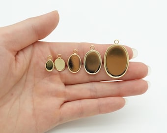 May include: A collection of gold-colored oval pendant trays in various sizes. Each tray has a loop at the top for attaching to a chain or cord. The trays are empty, ready to be filled with resin, photos, or other decorative elements.