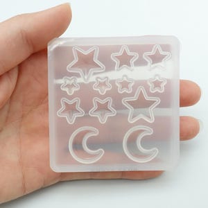 May include: Clear silicone mould with multiple star and crescent moon shapes. The mould is designed for making resin jewellery or other crafts.