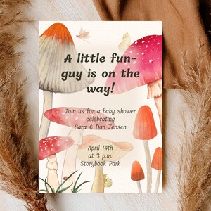 Könnte beinhalten: Eine Babyparty-Einladung mit Aquarell-Illustrationen von Pilzen in Rot-, Orange- und Beigetönen. Der Text lautet "A little fun-guy is on the way!" und lädt die Gäste ein, Sara & Dan Jensen am 14. April um 15:00 Uhr im Storybook Park zu feiern.