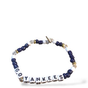 Op de afbeelding: Een donkerblauwe en witte kralen armband met de woorden "GO YANKEES" gespeld in witte letterkralen.