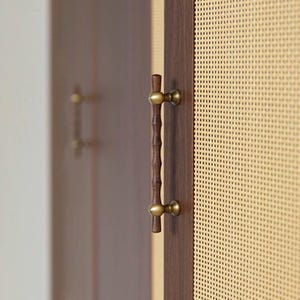 Puede incluir: Primer plano de una puerta de armario de madera con un tirador de estilo bambú y herrajes de latón. La puerta es de color marrón oscuro, y el tirador es de color marrón claro con un diseño texturizado. El fondo presenta un panel tejido.