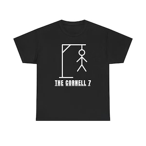 Könnte beinhalten: Ein schwarzes Kurzarm-T-Shirt mit einer weißen Grafik eines Strichmännchens, das an einem Galgen hängt. Unter der Grafik ist der Text THE CORNELL 7 in einer fetten, weißen, serifenlosen Schrift gedruckt. Das T-Shirt hat einen Rundhalsausschnitt.
