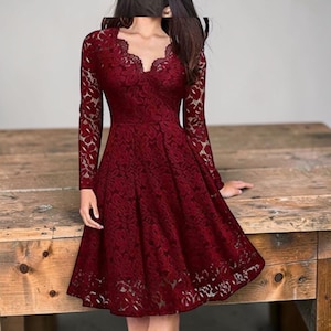 Vestido de festa vermelho vinho com renda, corte em A e decote em V, mangas compridas.