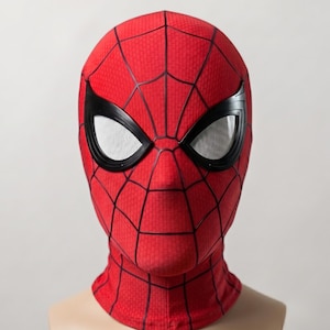 May include: A red fabric mask featuring a black web pattern across the entire surface. The mask includes two large, almond-shaped eye openings framed in black plastic with white mesh lenses, covering the head and neck area completely.
