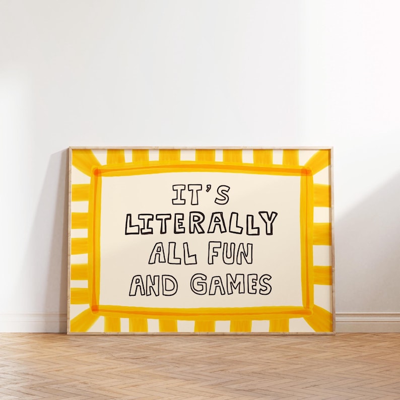 Pu&ograve; includere: Una stampa artistica da parete rettangolare con sfondo color crema e testo nero scritto a mano che recita IT'S LITERALLY ALL FUN AND GAMES. La stampa &egrave; racchiusa da un bordo giallo brillante con un motivo a strisce dipinte sui lati.