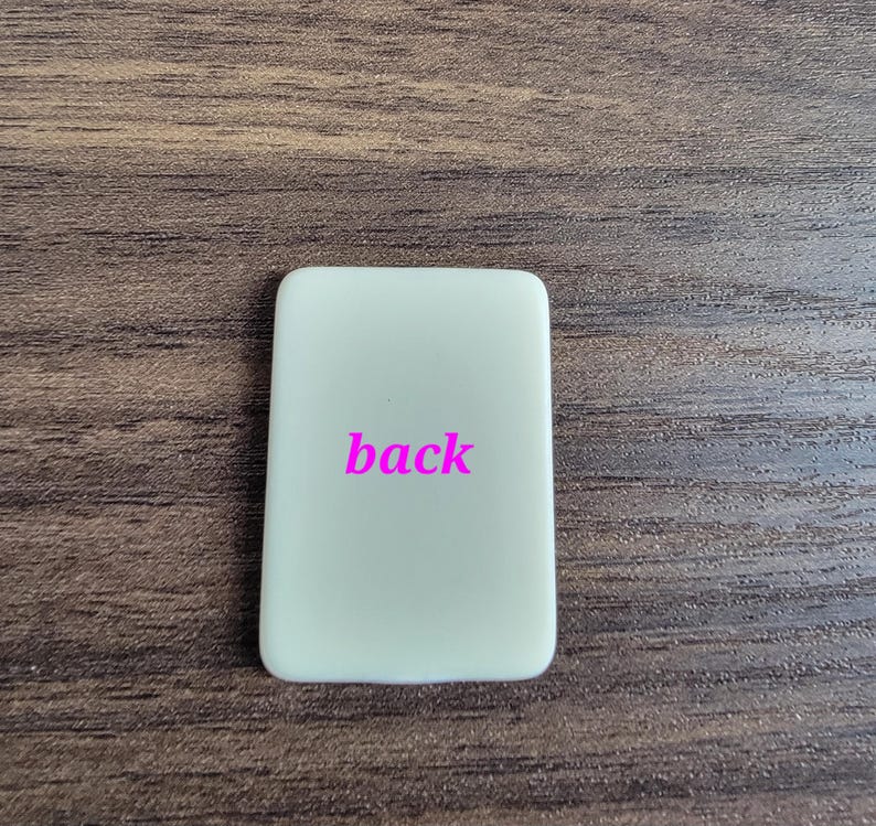 May include: A white rectangular sign with the word "back" printed in pink.