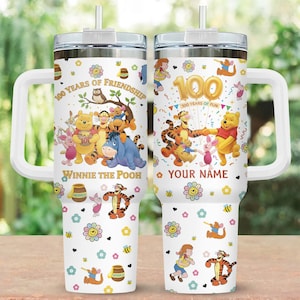 Puede incluir: Vaso blanco con personajes de Winnie the Pooh con el texto "100 Years of Friendship" y "100 Years of Fun". El diseño incluye ilustraciones de Pooh, Tigger, Piglet y Eeyore, junto con flores y abejas.