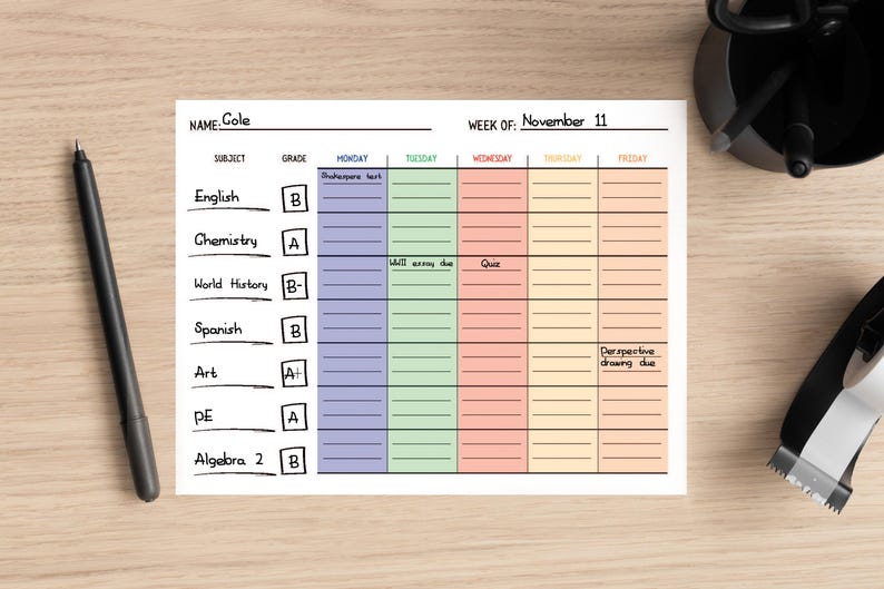 May include: A weekly planner with a light blue, green, orange, and yellow color scheme. The planner is labeled "Week of: November 11". The planner has columns for Monday, Tuesday, Wednesday, Thursday, and Friday. Each column has lines for writing in assignments and notes. The planner also has a section for subject, grade, and assignments due.