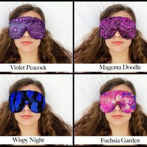 May include: Four sleep masks with various patterns and colours are shown. The masks are labelled "Violet Peacock", "Magenta Doodle", "Wispy Night", and "Fuchsia Garden". Each mask covers the eyes of a person.