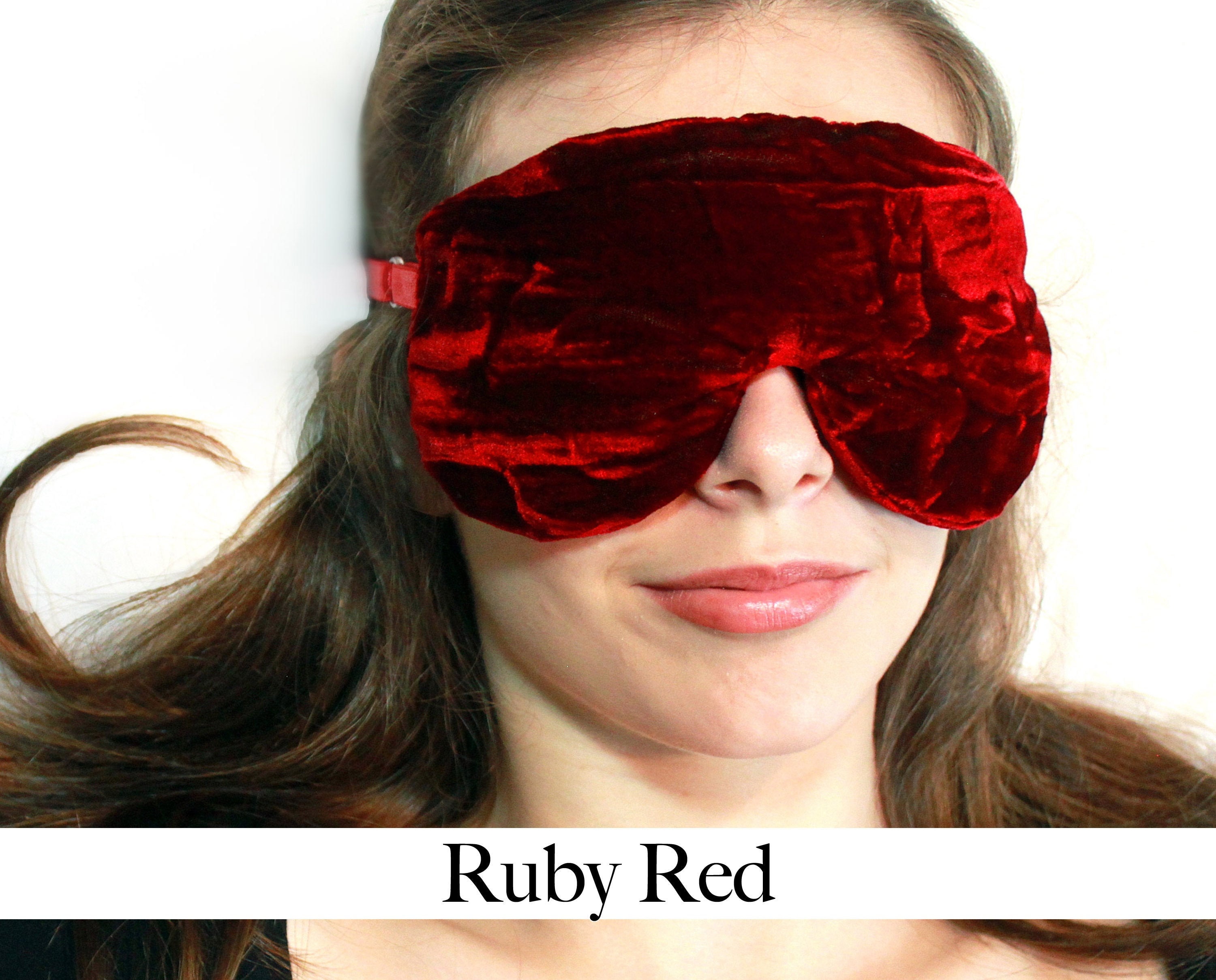 Close-up of woman wearing luxurious ruby red velvet blindfold, soft intimate sensual mood