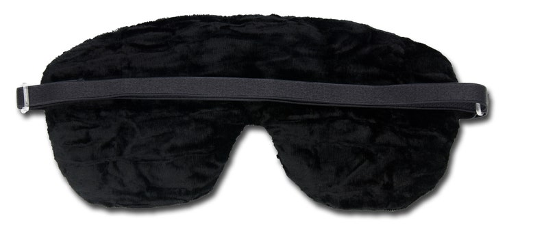 K&ouml;nnte beinhalten: Schwarze Schlafmaske mit verstellbarem Gummiband. Die Maske ist aus weichem, pl&uuml;schem Stoff.