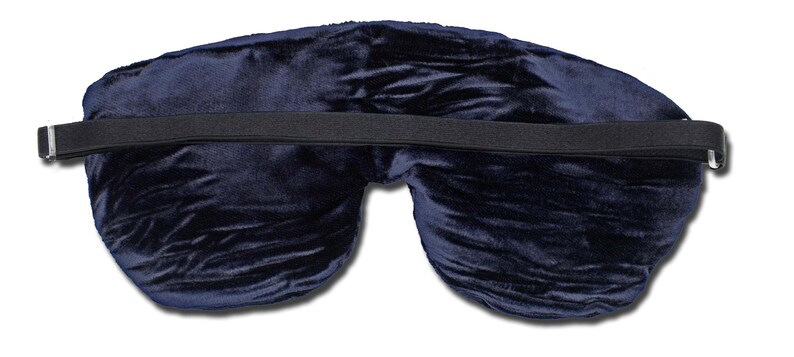 May include: A dark navy blue velvet sleep mask featuring a soft, plush texture and a contoured shape. The mask includes a wide, black elasticated strap that stretches horizontally across the back, secured with silver-toned metal adjusters on both ends.