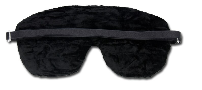 May include: A black sleep mask with a soft, textured surface. The mask has an elastic strap for securing it around the head. The mask is designed to block out light for better sleep.
