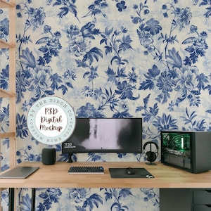 May include: A home office workspace with a computer monitor, keyboard, mouse, and a speaker. The wall behind the desk is covered in blue and white floral wallpaper. The wallpaper has a vintage, distressed look. The text "By The Birch Co. Custom Home Goods PSD Digital Mockup" is visible in a circle on the wall.