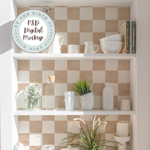 May include: A white shelving unit displays various kitchen and home decor items. The shelves hold jars, pitchers, bowls, books, plants, and a decorative plate. The background features a checkered pattern. The text "PSP Digital Mockup" is visible.
