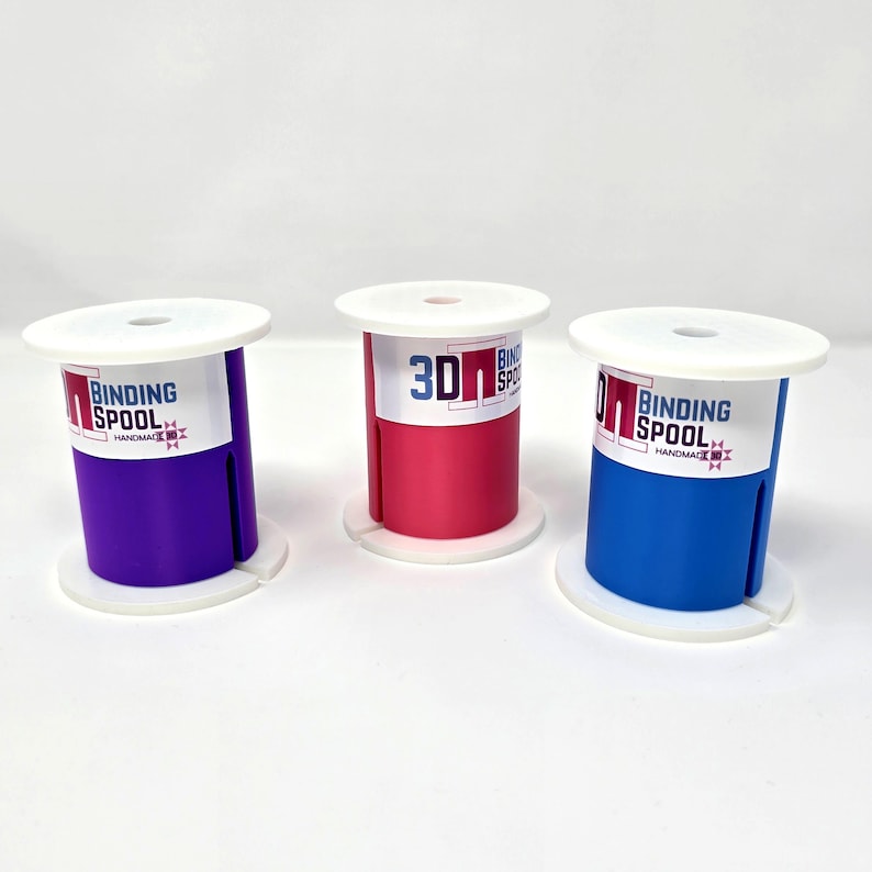 May include: Three colorful binding spools in purple, red, and blue. Each spool has a white top and base, with the words "BINDING SPOOL" printed on a label. The red spool has the number "30" printed on it.