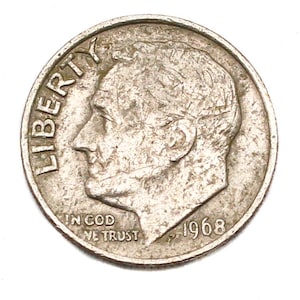 May include: A silver 1968 dime coin. The coin features a profile of a man, the word "LIBERTY", and the phrase "IN GOD WE TRUST". The year "1968" is also visible on the coin.