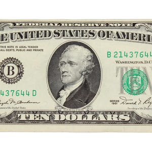 Puede incluir: Un billete de diez dólares estadounidenses. El billete presenta un retrato de Alexander Hamilton, el texto "TEN DOLLARS" y las palabras "The United States of America". El billete es principalmente verde y negro.