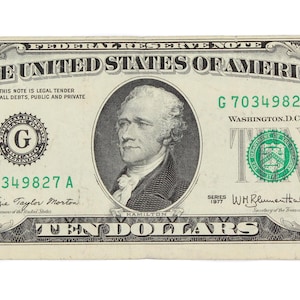 Puede incluir: Un billete de diez dólares de los Estados Unidos de América. El billete presenta un retrato de Alexander Hamilton y el texto "TEN DOLLARS". El billete es verde y negro con el texto "THE UNITED STATES OF AMERICA".
