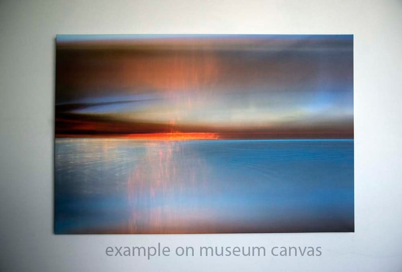 K&ouml;nnte beinhalten: Abstrakter Kunstdruck eines Sonnenuntergangs &uuml;ber einem Gew&auml;sser. Der Himmel ist eine Mischung aus Orange, Rosa und Blau, und das Wasser ist tiefblau. Das Bild ist verschwommen, was einen traumhaften Effekt erzeugt.